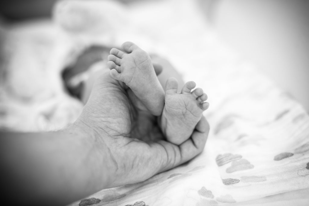 father holding baby's feet